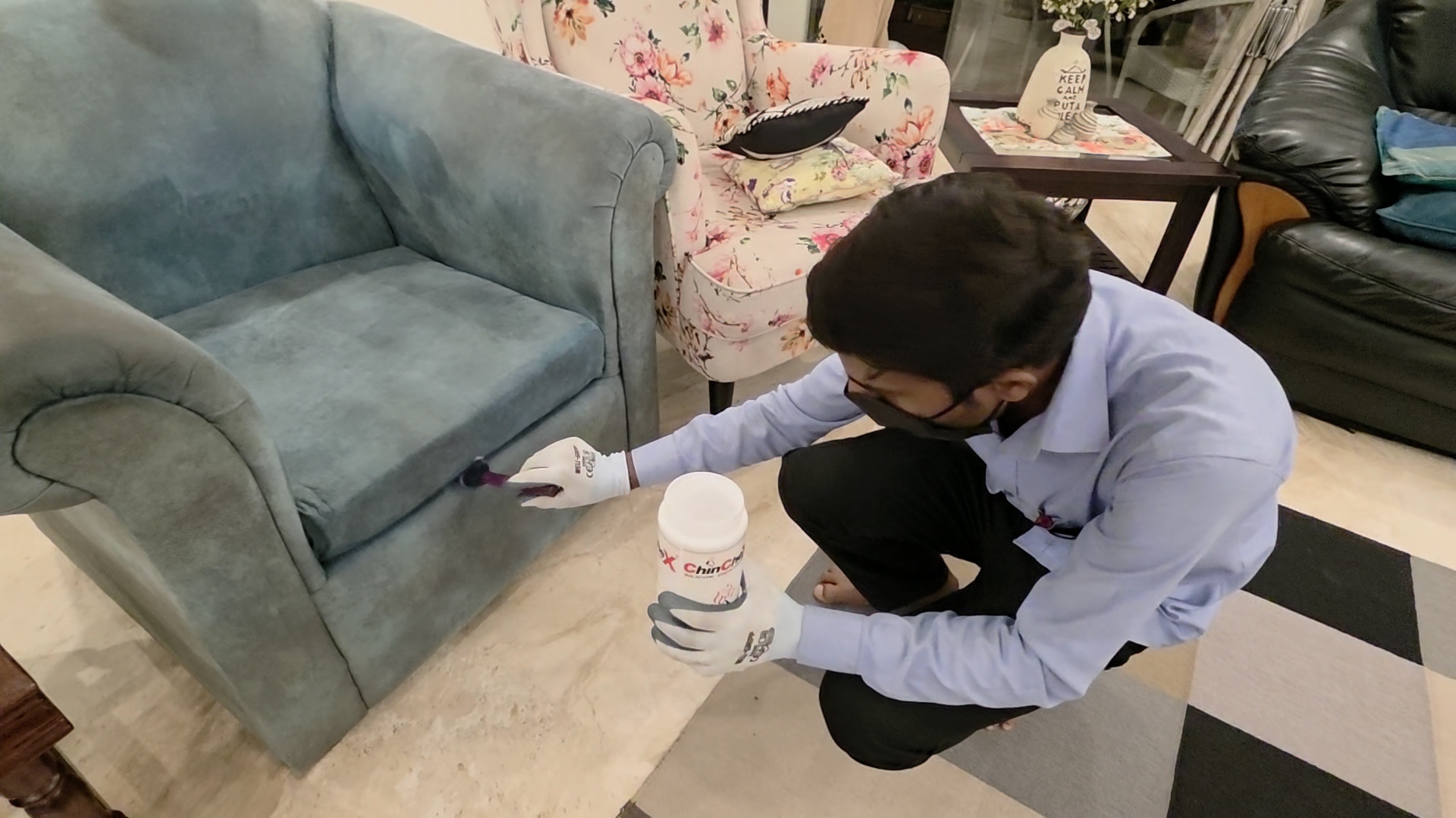 Seva technician applying ChinChex to a sofa with mask and gloves
